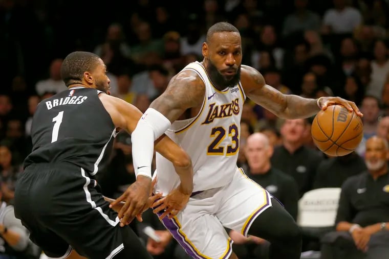 Los Angeles Lakers forward LeBron James (23) drives around Brooklyn Nets guard Mikal Bridges (1) during the first half of an NBA basketball game Sunday, March 31, 2024, in New York. (AP Photo/John Munson)