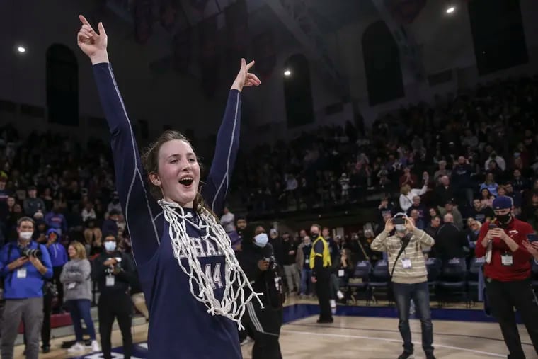 O'Hara's Maggie Doogan celebrates with the net after her team beat Carroll for the 2022 Catholic League Championship game at the Palestra. Doogan and two of her former teammates are playing in March Madness on the same day O'Hara looks for its third state title in four years.